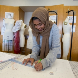 woman measuring in a room with mannequins